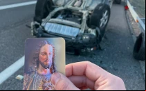 Jose María Mayoral sujeta la estampa del Sagrado Corazón de Jesús junto al lugar del accidente