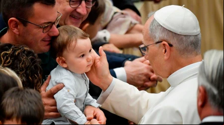 El Papa León XIV acaricia a un niño presente en el Aula Nervi del Vaticano.